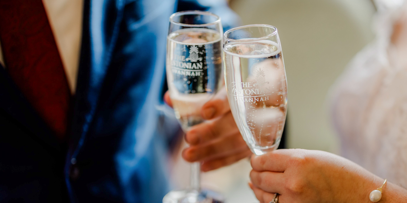 a pair of hands holding champagne glasses